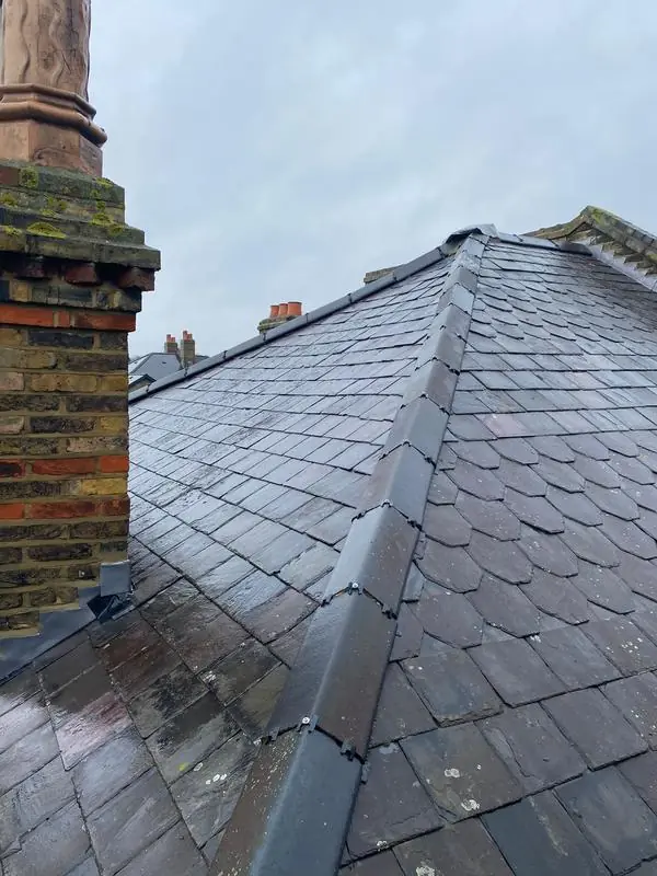 Chimney stack with new lead flashing where it meets a slate roof and its hip