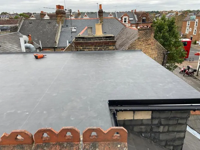 Rubber flat roof on a rear dormer, with clay ridge tiles in the foreground and rooftops behind