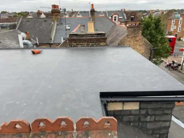 Rubber flat roof on a rear dormer, with clay ridge tiles in the foreground and rooftops behind