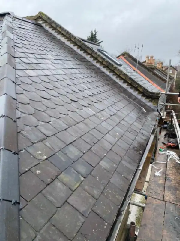 Slate roof with a new ridge line, seen from the scaffold along the top of the roof